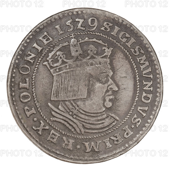 Forgery of a crown thaler imitating Sigismund I the Old (King of Poland; 1506–1548), made by Gotfryd Majnert (1767–1846), falsely dated 1529 but made in 1836. Obverse: bust of Sigismund I in a cap, crown and armor, turned right, inscription SIGISMVNDVS.PRIM.REX.POLONIE. Reverse: Polish coat of arms under a crown surrounded by Sforza coats of arms, Ruthenia, Prussia and Lithuania, inscription DEVS.IN.VIRTVTE.TVA.LETABITVR.REX. Coin; diameter 43.4 mm, weight 26.87 g., A round metallic coin with a worn surface showing a high-relief profile of a crowned person facing right, wearing a crown with decorative elements and a textured headdress, and a layered garment or collar around the neck; the coin has a beaded inner border and a raised outer rim with several raised characters around the edge that are not described; overall colors visible are shades of gray, silver, and darker tarnished gray-brown on the metal, with varied patina creating lighter and darker areas across the surface.