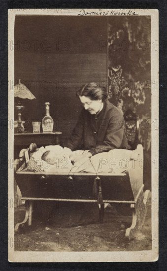 Portrait of Celina Dominikowska née Tretery (?–1910) with Kordzio in a cradle. Photographer: F. Sternberg (Przemysl; photographic studio). Subjects: cradles, children; portrait of a woman with a child. Medium: print glued to cardboard over the entire surface; carte de visite photographic print. Date: 1871, place: Przemysl. Photograph dimensions: print height 9.6 cm, width 5.6 cm; support height 10.3 cm, width 6.1 cm.