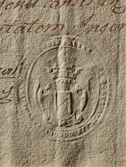 Seal of Jan Onufry Ossolinski, Starost of Drohicz; Oval seal impression. In a decorative crowned cartouche, the Topór coat of arms with a jewel. Illegible inscription on the rim. Maker: Zurakowski, Witold (?-1927). Date: 1781. Materials/function: seal, private seal/document seal, coat of arms seal, seal of a starost. Dimensions: 35.3 mm and 41 mm., The image shows a textured piece of paper in beige and tan tones with an embossed circular seal featuring a crowned shield and ornamental flourishes; there is brown ink handwriting partially visible near the top and left edges, and the paper surface displays varying shadows and creases.