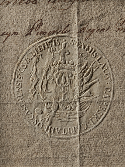 Round seal impression of the starost of Kowal, Stanislaw Dambski. In a decorative cartouche with a jewel, the Godziemba coat of arms; on the sides the date 17 66; behind the cartouche a panoply. In the rim an inscription: STANISLAUS DAMBSKI CAPITANEUS CASTRENSIS COVALIENSIS, 1766, Poland., A close-up of a textured beige paper showing a circular embossed seal with raised decorative elements and a central coat of arms; the seal displays a shield-like central motif topped by a small standing figure and surrounded by ornate flourishes and banners, with a few curved lines and ridges from the embossing creating shadows; the paper has a vertical fold line and a horizontal crease, and there is a group of dark brown ink strokes near the top edge.