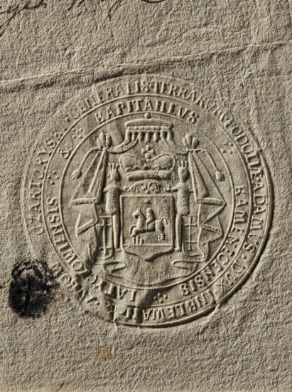 Seal of Adam Czartoryski, Starost of Latyczów; Czartoryski, Adam (fl. ca. 1765); Zurakowski, Witold (?-1927). Round seal impression of the Starost of Latyczów, Adam Czartoryski. Under an ermine mantle topped with a rank crown, a shield with the Pogon coat of arms beneath a mitre, supported by two knights with shields. On the double rim, the inscription: GENERALIS TERRARUM PODOLIAE ADAMUS DUX IN KLEWAN & ZUBOW CZARTORYSKI // KAPITANEUS KAMIENECENSIS LATYCZOWIENSIS. 1793, Poland., The image shows an embossed circular seal pressed into textured beige paper, with a central coat of arms featuring a shield bearing a mounted rider, flanked by draped banners and topped by a crown or ornamental canopy; the seal's raised details create shadows in tan and light brown tones. There is a dark irregular ink blot near the lower left of the seal in black, and a small brownish spot below the seal; the overall visible colors are beige, tan, light brown, dark brown, black, and a hint of gray in the paper ...