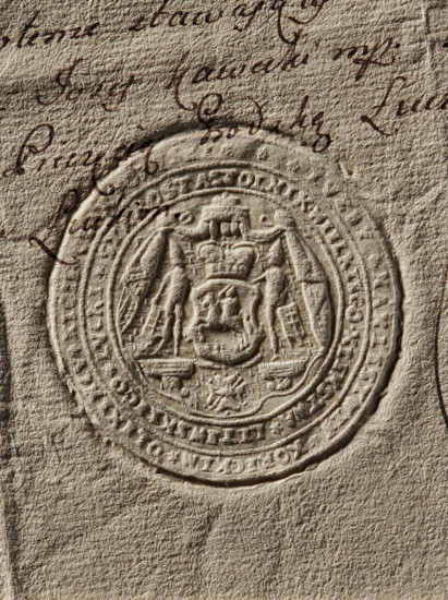 Seal of Józef Klemens Czartoryski, Starost of Luck; round imprint. A shield with the Pogon coat of arms under a mitre placed on an ermine cloak, on a console; flanked by two knights; below, on a ribbon, the Order of the White Eagle. In the double rim a partially illegible inscription: JUZEF NAXIENSTWIE KORECKIM OLIXINCV XIOZE, // STOLNIK WIELKIEGO XSIENSTWA LITEWSKIEGO LUCKI STAROSTA, 1776, Poland, seal, The image shows a close-up of textured beige paper with an embossed circular seal featuring a detailed coat of arms in its center, surrounded by concentric raised rings and decorative patterns; there is a group of dark brown handwritten ink marks and cursive strokes near the top and left edges of the seal, and the visible colors are beige, tan, and dark brown.