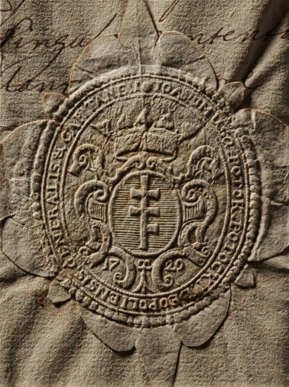 Oval impression of the seal of Joachim Potocki, starost of Lviv. On a decorative oval shield with a rank crown, on a blue background the Pilawa coat of arms. Below the shield, the date 17 / 29. In the rim the inscription: JOAIMUS Q. POTOK POTOCKI LEOPOLIENSIS GENERALIS & CAPITANEUS. 1729. Poland, stamp; size 1: 43.5 mm; size 2: 61 mm., A close-up of an embossed circular seal pressed into aged, textured paper, showing a central shield-like emblem with a vertical element and surrounding ornamental scrollwork, topped by a stylized crown, all rendered in raised, carved detail; the paper has a rough, fibrous surface with visible creases and folds, and a few torn petal-like edges around the seal; colors visible are various tones of beige, tan, brown, and a few darker brown accents in the embossed shadows and in a few thin handwritten strokes partially visible beneath the seal.