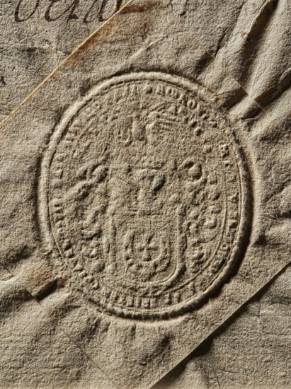 Starost of Oswiecim seal, Starost of Oswiecim (ca. 1658) — Oval seal impression. Shield with the Jastrzebiec coat of arms, with rich labres and a jewel above a crowned helmet. Illegible inscription on the rim. 1658, Poland, seal; dimensions 1: 39.1 mm, dimensions 2: 46.9 mm, A close-up of a textured, folded paper surface in beige and tan tones showing an embossed circular seal with raised ornamental patterns and a central shield-like motif, with visible creases and shadows in darker brown and gray highlighting the paper fibers and folded edges.