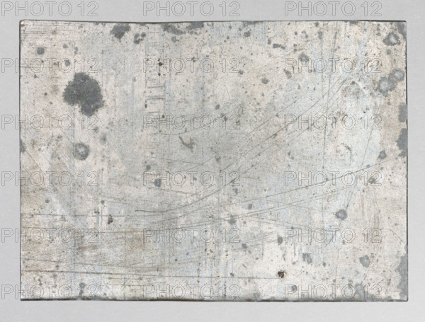 Landscape with trees and defensive buildings; Feliks Jablczynski (1865–1928); Polish graphic artist; ca. 1924; graphic plate (graphic matrix); height 7.6 cm, width 10.7 cm; subject: trees and defensive architecture., A rectangular, weathered metal plate sits against a neutral background, showing a mottled surface with a mix of light gray, off-white, pale blue, and darker gray areas; the plate has several irregular dark gray blotches and spots, many faint fine scratches and scuff marks that form curved and straight lines across the surface, and a few small pits and stains with subtle brownish discoloration near some edges.