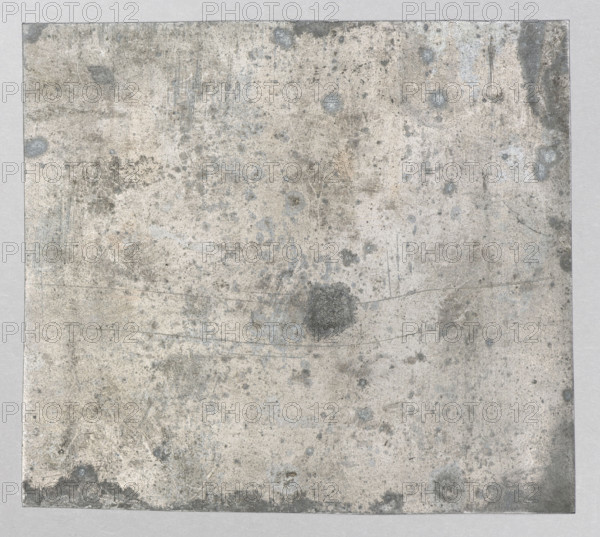 View of an impressive building with a corner tower; Feliks Jablczynski (1865–1928), Polish graphic artist; ca. 1924; graphic art, graphic matrix/plate; height 9 cm, width 10.1 cm; trees; architectural view., A square surface fills the image showing a worn, textured sheet with an overall pale gray and off-white background mottled with areas of darker gray and light blue-gray spots and stains; there are several smudges and blotches in muted brownish-gray, faint scratches and thin lines crisscrossing the surface, a few circular darker stains, and a subtle darker border around the outer edges.