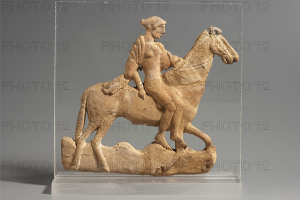 Appliqué depicting a woman riding a horse, author reclaimed, reclaimed (Silesia), 5th century, Melos (Greece), terracotta. 'Relief from Melos' — the plaque depicts a young woman riding a ram, of which only the torso with the heads of two horses glued on has survived. The woman is dressed in a tight-fitting tunic, a cloak draped over her back, and a headdress. 460–450 BC, Melos (Greece), bas-relief, height 13.5 cm, width 13.5 cm, weight 0.09 kg.