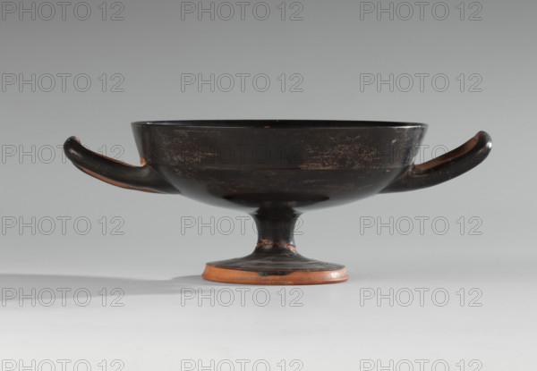 Black-finned kylix, Vicup type. Vicup-type kylixes are characterized by a straight edge and a concave outer wall of the foot, which has a reserved surface. The lower surface of the foot is concave, decorated with a wide band of black varnish. The vessel has two handles mounted at the level of the rim. WQXBCFS
I:\nmw crop ready cleaned\ WQXBCFS
I:\nmw crop ready cleaned\Technology: The entire surface is covered with an evenly distributed, glossy black varnish of good quality. Traces of turning are visible under the varnish. The clay is cleaned. WQXBCFS
I:\nmw crop ready cleaned\ WQXBCFS
I:\nmw crop ready cleaned\Comments: The surface is dirty, with visible chips, scratches, and abrasions. Fragment of the foot is glued on. Visible conservation additions. WQXBCFS
I:\nmw crop ready cleaned\ WQXBCFS
I:\nmw crop ready cleaned\Clay color: 2.5 YR 6/6 (light red). Varnish color: 10 YR 2/1 (black). Date: ca. 480 BC. Provenance: Attica. Vessel type: kylix. Dimensions: height 7.6 cm; width 2...