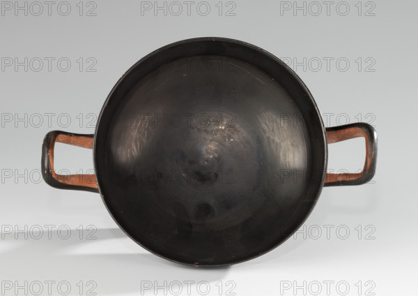 Black-finned kylix, Vicup type. Vicup-type kylixes are characterized by a straight edge and a concave outer wall of the foot with a reserved surface. The lower surface of the foot is concave, decorated with a wide band of black varnish. The vessel has two handles mounted at the level of the rim. Technology: entire surface covered with an evenly distributed, glossy black varnish of good quality; traces of turning visible under the varnish; clay cleaned. Comments: surface dirty, with visible chips, scratches, and abrasions; fragment of the foot glued on; visible conservation additions. Clay color: 2.5 YR 6/6 (light red). Varnish color: 10 YR 2/1 (black). Ca. 480 BC (ML Bernhard dates the monument to ca. 480 BC). Origin: Attica. Object type: vessel, kylix. Dimensions: height 7.6 cm, width 20.7 cm, depth 14.2 cm; weight 0.210 kg.