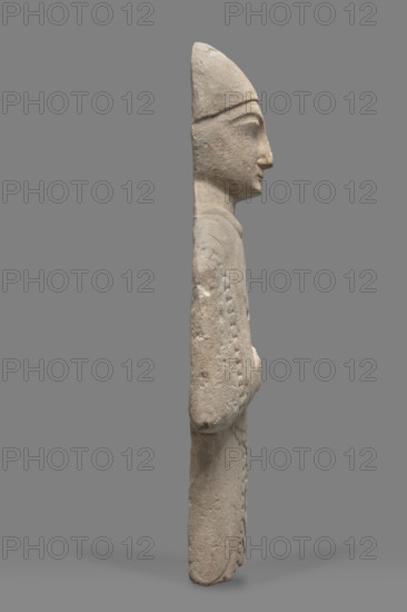 Fragment of a votive figure of a man. The fragment depicts a standing man dressed in a tutulus and himation. The outer edge of the himation is framed by an ornament in the form of semicircular serrated edges. The torso is flattened, the front part is carefully detailed, while the back is flat. The right arm, bent at the elbow, rests on the chest. The right hand is lowered down, close to the torso, the hand clenched into a fist. The face is oval, elongated. The chin is small, the lips are thin, and the nose is long and aquiline. The eyes are slanted and prominent, the eyebrows are arched, and the forehead is low. Conical headdress. Proto-Cypriot Style II, circa 600–480 BC. Cyprus; sculpture; height 28 cm, width 14 cm.