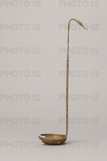 Shallow dipper with a quadrilateral handle, narrowed at the top. The end of the handle is in the shape of an elongated bird's head (swan). The round dipper has a shallow bottom, its edges are slightly thickened. A hole is visible in the dipper. The surface of the object is uneven (corroded). Etruria; vessel. Height 31.2 cm, width 7.5 cm. Maker/date: Antoni Madeyski (1862–1939) — scenography/gallery/classical?