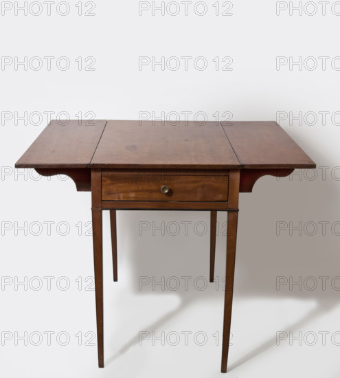 Table, rectangular, with flaps on the long sides and a drawer on one of the short sides, supported by four slender, angular, tapering legs. Edges of the legs and the lower edge of the frame are edged with ebony veining. The flaps are on steel hinges, supported when raised on rotating supports mounted on wooden hinges. Neoclassicism (style), mahogany, early 19th century, England, height 67.6 cm, width 92.8 cm, depth 91 cm.