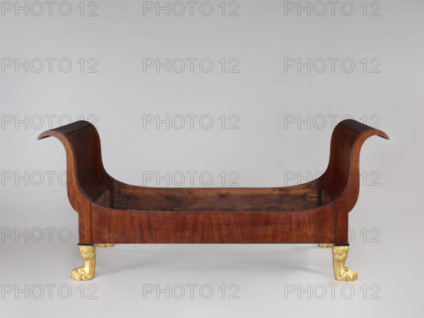 Bed, animal paws, Empire (style), bedrooms, Empire bed, mahogany, with S-shaped outward-curving pediments of equal height and straight side boards, supported by four carved, gilded legs in the form of furry animal paws. Frame pediments with single panels, with strong upturns at the top, simple at the bottom, connected to the sides with screws and hooks. The sides at the upper corners arch into the pediment frames; on the inner side, at the bottom with glued-on toothed strips supporting the cross slats under the mattress. One of the pediments veneered on the outside with ash stained mahogany. 1815–1830. Warsaw, Central Europe. Furniture; bed. Height 103 cm; width 192 cm; depth 94.5 cm.