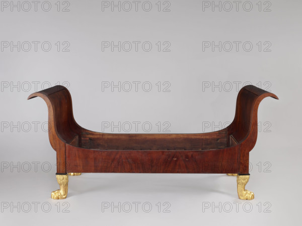 Bed with animal-paw legs in Empire style for bedrooms. Mahogany bed with S-shaped outward-curving pediments of equal height and straight side boards, supported by four carved, gilded legs in the form of furry animal paws. Frame pediments with single panels, strong upturns at the top, simple at the bottom, connected to the sides with screws and hooks. Upper corners of the sides arch into the pediment frames; inner side at the bottom has glued-on toothed strips supporting the cross slats under the mattress. One pediment veneered on the outside with ash-stained mahogany. Dated 1815–1830, Warsaw, Central Europe. Dimensions: height 103 cm, width 192 cm, depth 94.5 cm.