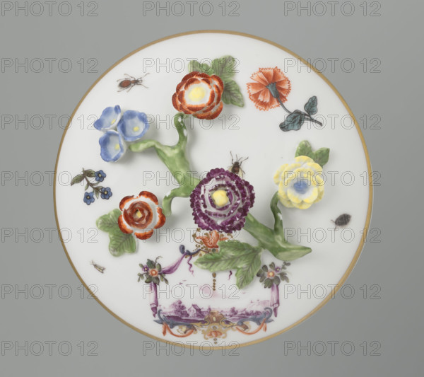 Sugar bowl with a lid and a branch handle, Koenigliche Porzellain Fabrique, Meissen (1710–1763), manufacturer. Cylindrical sugar bowl, rounded at the base, with a slightly arched lid and a plastic, colorfully painted branch handle featuring four flowers and leaves at the ends of the side shoots: three forget-me-nots, two brick-red flowers and one yellow. On the sides of the body are two cartouche frames and on the cover one, each framed by two purple draperies suspended from the sides on small flower bouquets and dry rocailles, topped and bottomed on the symmetry axis with brick-red draperies suspended on plant branches. Within the cartouches are landscape miniatures with architecture and staffage painted in purple camaieu: (1) a fragment of a hill with trees, two figures, and a building in a valley; (2) two buildings among bushes; cover: (3) a plateau with a house and a hill in the distance on the right. Between the cartouches on the body are two colorful ornamental-floral motifs; on ...