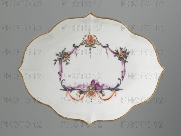 4-leaf oblong dessert bowl, Meissen (ca. 1750), Koenigliche Porzellain Fabrique, manufacturer. Four-part, multi-leaf design. At the bottom a cartouche frame with a motif of two purple draperies suspended on the sides on small flower bouquets and dry rocailles, topped and bottomed on the axis of symmetry with a brick-red and gold ornamental motif, with brick-red draperies suspended on both sides on plant branches at the bottom. In the cartouche, a miniature in purple camaïeu: a lowland landscape with buildings and a group of three figures on the left. Rim gilded. Porcelain vessel. Height 3.3 cm; width 17.3 cm; depth 13 cm. Manufacturer dates 1710–1763.
