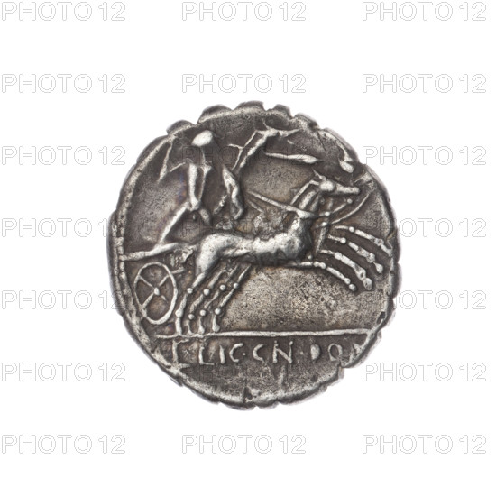 Denarius serratus, 118 BC. Obverse: Head of Roma in an Attic helmet right; inscription L.COSCO.MF (S lying) around, sign of value X behind; beaded border. Reverse: Naked warrior on a biga right, holding reins, shield and carnyx in left hand and a spear in the right; inscription L.LIC.CN.DOM under the line; pearl border. Makers/publishers: Cosconius, L. (fl. 118 BC); Licinius Crassus, L. (fl. 118 BC); Domitius Ahenobarbus, Cn. (fl. 118–96 BC). Roman Republic (505–27 BC). Coin: serrated edge, diameter 17.8 mm, weight 3.86 g, axis 270°.