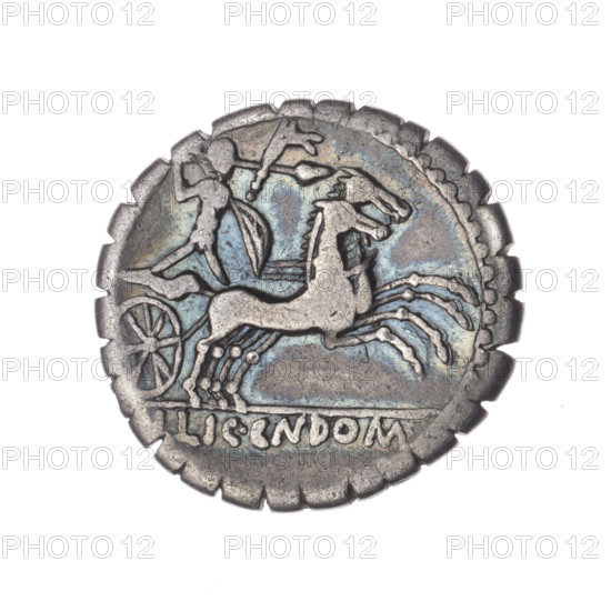 Denarius serratus; publishers: L. Pomponius (fl. 118 BC), L. Licinius Crassus (fl. 118 BC), Cn. Domitius Ahenobarbus (fl. 118–96 BC). Imagery: head of Roma in an Attic helmet right on obverse; behind her the sign of value X; pearl border. Inscription around obverse: L.POMPONI.CNF (M and second P lying down, NF in ligature). Reverse: naked warrior on a biga right, holding reins and a carnyx in his left hand, a spear in his right and a shield; inscription under the line L.LIC.CN.DOM; pearl border. Iconography includes helmets, shields, spears, carnyx, warrior on a biga, Attic helmets. Date: 118 BC, Roman Republic. Place: Narbonne. Medium: coin (denarius), serrated; diameter 20.6 mm, weight 3.95 g, axis 180°.