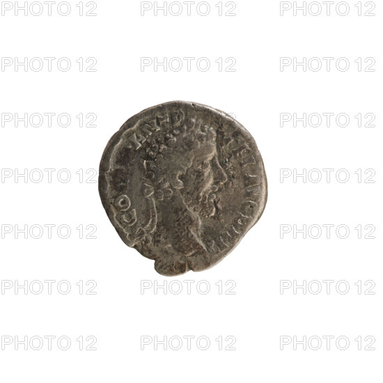 Denarius of Commodus (161–192; Roman emperor 177–192). Obverse: Laureate bust of the emperor facing right; legend MM ANT P FEL AVG BRIT (end of legend poorly legible). Reverse: Victoria standing right, resting her leg on a helmet, mounting a shield with an inscription on a palm tree trunk; reverse legend X IMP VII COS IIII PP. Pearled border. Roman Empire, circa 184–185. Silver coin, weight 2.60 g, axis 180°.