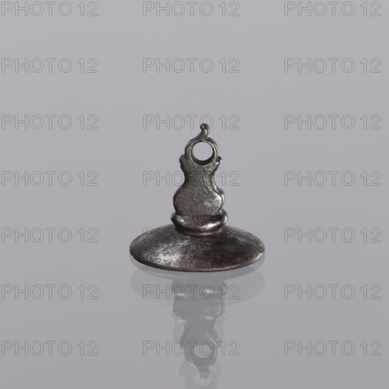 Sealing wax stamp keyring: oval sealing wax stamp with a decorative handle and a hole for hanging on a belt. In the oval field, a circular cartouche contains a mounted lion with a raised tail set on a column. Rich labyrinthine floral wreaths. Above the closed tournament helmet, between two eagle wings, the coat of arms is repeated (Lew VI variety). Late 18th–early 19th century, Poland. Seal; height 21 mm, width 22 mm, depth 20 mm.