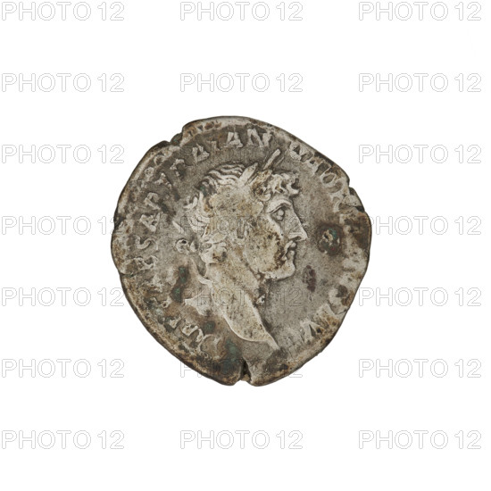 Denarius, Hadrian (76–138; Roman emperor 117–138). Obverse: Bust of Hadrian with laurel wreath facing right; rim inscription: IMPCAESARTRAIANHADRIANVSAVG. Reverse: Roma seated left on a chair, wearing a long dress and helmet, holding a figure of Victoria in her outstretched right hand and a spear placed vertically in her left; rim inscription: PMTRPCOSIII. Circa 119–122. Rome, Roman Empire (27 BC–476). Silver coin, weight 3.28 g.