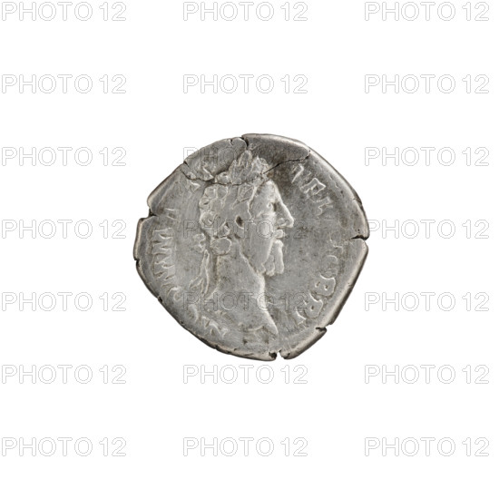 Denarius of Commodus (161–192; Roman emperor 177–192). Obverse: Head of Commodus in a laurel wreath to the right, inscribed M COMM A P - FEL AVG BRIT. Reverse: Victoria half-naked, with her foot on a helmet on the ground, stands right and attaches a shield inscribed VO/DE to a tree trunk; around inscription SA C FEL PM TR P XI IMP VII COS V PP. Roman Empire, 186. Coin. Diameter 17.5–18.5 mm, weight 2.75 g, axis 180°.