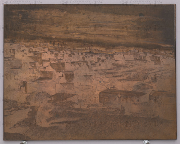 Middle Eastern city; graphic artist Dominik Witke-Jezewski (1862–1944); after 1900; graphic plate/graphic matrix; graphic; height 14.7 cm, width 18.2 cm, thickness 0.4 cm., The image shows a rectangular metal plate with an engraved scene of a village landscape. The surface displays a range of brown and copper tones with darker brown areas creating contrast; there are hints of black in the upper sky area and some muted gray along the outer border. The engraving depicts a group of flat-roofed buildings clustered across the middle of the plate, a few larger rectangular structures in the foreground, and textured terrain with etched vegetation and shrubs. The sky area above the village is filled with horizontal engraved strokes, and the lower margin shows a darker, more densely engraved foreground. The plate rests against a pale neutral background, and small metal supports are visible at the bottom edge.