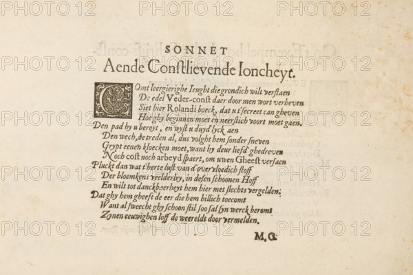 Sonnet aende constlievende joncheyt, Dutch-language sonnet, 't Magazin oft pac-huys der loffelycker penn-const, albumblad, text sheet, Text sheet with a sonnet as an introductory poem in 't Magazin oft pac-huys. The text begins with a decorated initial C. The text sheet is part of an album., writer (clerical worker): unknown, publisher: David Roelands, Flushing, 1616 - 1617, writer (clerical worker), paper, letterpress printing, woodcut, text in letterpress, height 225 mm x width 335 mm, initial, A portion of aged paper with printed lines of decorative serif text centered near the top and a rectangular ornate initial block featuring a floral or foliate design to the left of the first lines; the page shows dark printed ink that forms several lines of flowing italic script beneath the large centered heading, faint bleed-through of text from the reverse visible in places, small scattered brown foxing spots across the paper, and a small set of bold initials near the lower right of the prin...