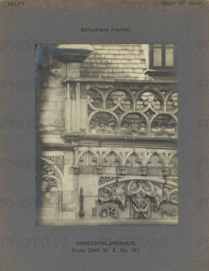 Gemeentelandshuis. Oude Delft WZ No. 167. Balustrade (right), Façade with decorations and a balustrade of the Gemeenlandshuis on the Oude Delft in Delft, photograph, inscription: 'The right of reproduction of these photos is reserved by the Publisher.', number: '19', inscription: 'Delft. Early 16th century.', Delft, c. 1900 - c. 1904, photographer, paper, pasteboard, gelatin silver print, gelatin silver development, height 141 mm x width 111 mm, ornament derived from plant forms, balustrade, Gemeenlandshuis, A close-up photograph of a stone facade showing ornate carved balustrades and decorative arches, with weathered stone blocks and a ledge above the balustrade, a section of tiled roof and a window visible at the top right, and a dark vertical metal hinge or handle affixed to the stone at mid left, all presented within a dark rectangular mat with printed labels above and below the photograph.