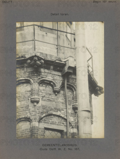 Detail of the tower of the Gemeenlandshuis on the Oude Delft in Delft, Gemeentelandshuis. Oude Delft WZ No. 167. Detail tower, photograph, number: '22', inscription: 'Delft. Early 16th century.', inscription: 'The right of reproduction of these photos is reserved by the Publisher.', Delft, c. 1900 - c. 1904, photographer, paper, pasteboard, gelatin silver print, height 155 mm x width 117 mm, tower (of house or building), Gemeenlandshuis, A close view of a brick corner of a building showing decorative arched brickwork and carved stone corbels beneath a projecting stone ledge, with a vertical drainpipe running down beside the masonry and a large cylindrical column in front, and a metal railing and wall visible above the ledge.