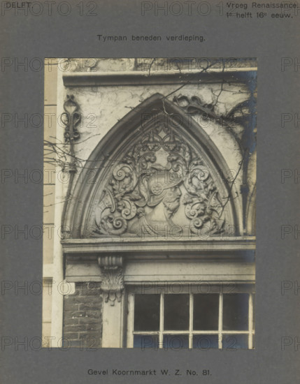Tympan on the facade of a house on the Koornmarkt in Delft, decorated with a man's head with a helmet, Facade Koornmarkt WZ No. 81. Tympan ground floor, photograph, inscription: 'Delft. Early Renaissance. 1st half of the 16th century.', inscription: 'The right of reproduction of these photos is reserved by the Publisher.', number: '30', Delft, c. 1900 - c. 1904, photographer, paper, pasteboard, gelatin silver print, height 154 mm x width 113 mm, ornament derived from plant forms, urban housing, ornament derived from architectural details, Koornmarkt, A close photographic view of a carved stone architectural tympanum above a window, showing an arched triangular panel with ornate floral scrollwork surrounding a carved profile of a bearded male figure wearing a helmet, flanked by decorative foliate motifs and volutes, with a molded arch frame and a projecting cornice above, a carved corbel beneath the cornice with acanthus-like ornament supporting the entablature, a multi-pane window belo...
