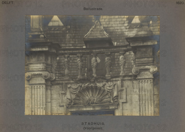 Balustrade on the town hall in Delft, Town Hall (Facade). Balustrade, photograph, inscription: 'The right of reproduction of these photos is reserved by the Publisher.', number: '50', inscription: 'Delft. 1620.', Delft, c. 1900 - c. 1904, photographer, paper, pasteboard, gelatin silver print, height 115 mm x width 156 mm, town hall, balustrade, A photographic detail of a stone façade showing architectural ornamentation including balusters, carved pilasters with fluted shafts and decorated capitals, a broken pediment with draped swags, a scallop shell motif with a central carved face, ornate scrolls and molded cornices, a tiled roof area above with decorative stone elements and a small window opening partially obscured by the balustrade, all presented within a wider neutral-toned mounting.