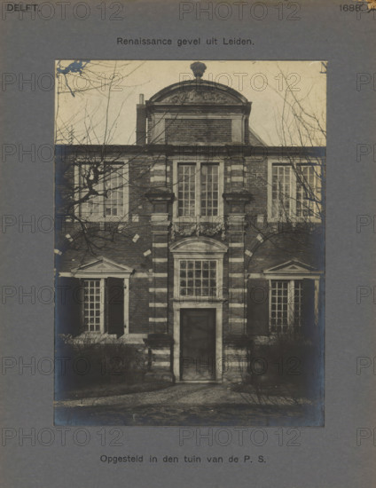 Placed in the garden of the PS Renaissance facade from Leiden, Facade in the garden of the Prinsenhof in Delft, photograph, inscription: 'Delft. 1688.', number: '60', inscription: 'The right of reproduction of these photos is reserved by the Publisher.', Delft, c. 1900 - c. 1904, photographer, paper, pasteboard, gelatin silver print, height 158 mm x width 117 mm, Prinsenhof (Delft), The image shows the façade of a brick building with a central doorway topped by a rectangular window and decorative stonework, flanked by tall, multi-paned windows with shutters and triangular pediments above the side entrances, a second-story set of tall windows above the doorway, and a rounded gable with ornamental detailing and a sculpted urn at the top; leafless tree branches partially obscure the façade and cast shadows across the brickwork, and the photograph is mounted on a textured mat with borders visible around the image.