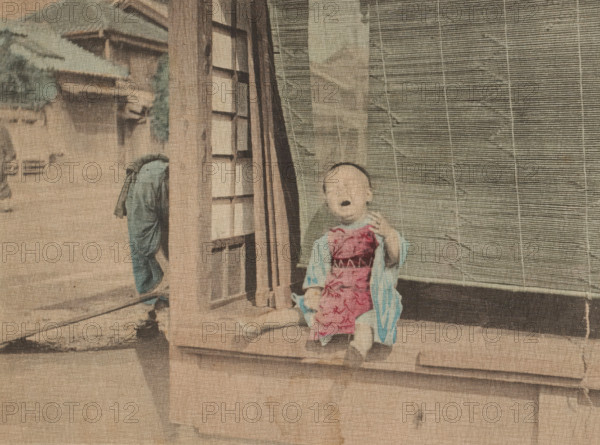 Mamma!, Crying Little Child, page, photomechanical print, c. 1891 - in or before 1896, collotype process, height 134 mm x width 173 mm, toddler (male), crying, shouting, Japan, A faded photograph showing a small child sitting on a wooden step in front of a door with a slatted screen beside it, the child wearing a patterned garment over a lighter robe and sandals, an adult figure partially visible walking away on a street with traditional buildings and tiled roofs in the background, all rendered in muted, aged colors with visible paper texture and signs of wear.