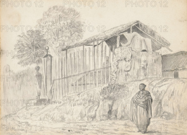 View of an open shed and entrance of a yard, sketchbook page, In the foreground runs a road curving to the rear left with a high, overgrown verge. A woman stands on the road to the right. She is dressed in a foot-length wrap skirt (redda) and a wide shawl around her upper body and arms. Her hair is styled in a bun (condé). To the left in the verge, a few steps lead to a simple wooden entrance gate with a (metal?) roof, topped with a sphere. On the sidewalk in front of the gate stands a person dressed in a calf-length hip cloth (veshti, lungi) with a bare torso. His hair is styled up at the back. To the right of the entrance begins a fence of vertical posts and slats, connected halfway by a long horizontal slat. Through the fence, the wooden skeleton of a shed topped with a double roof of woven coconut palm leaves (cadjan) is visible. On the right side of the barn, a wall has been constructed halfway up in the traditional manner: woven screens of wicker, palm leaf, and/or wood (warichch...