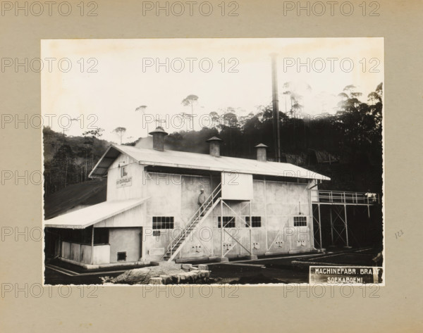 Daradjat Cinchona Enterprise, album page, photograph, Album page with a photograph of a building of the Daradjat cinchona enterprise, built in 1935 by Braat Soekaboemi. Part of a photo album with photographs of machines and constructions of the NV Machinefabriek Braat in Surabaya, Soekaboemi, and Tegal from the period 1931-1937., West Java, 1935, photographer, Java, paper, pasteboard, gelatin silver print, height 165 mm x width 232 mm, height 250 mm x width 320 mm, Person, NV Machinefabriek Braat, factory-building, economic history, overseas history, company history, cinchona cultivation, Period, 1931 - 1937, A black and white photograph of an industrial building with a corrugated metal roof and three cylindrical vents protruding from the rooftop, a tall vertical smokestack rising behind the structure, a set of exterior stairs leading to an upper doorway with a person standing on the landing, multiple small rectangular windows along the building facade, structural support beams and a r...