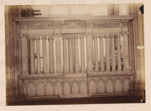 Choir screen in the Dom of Utrecht, photograph, annotation: 'Domkerk te Utrecht, Afsluiting hek, Sept 1891', annotation: 'Utrecht', Dom of Utrecht, 1891, photographer, Utrecht, Attributed to, paper, pasteboard, albumen print, albumendruk, height 170 mm x width 238 mm, parts of church interior: choir, A section of an ornate stone balustrade with a row of vertical columns topped by carved capitals and a profiled horizontal entablature, decorative frieze panels with sculpted foliage and cartouche motifs above, and a patterned lower panel of pointed arch shapes and tracery, flanked by larger vertical pilasters and set against tall stone wall surfaces.