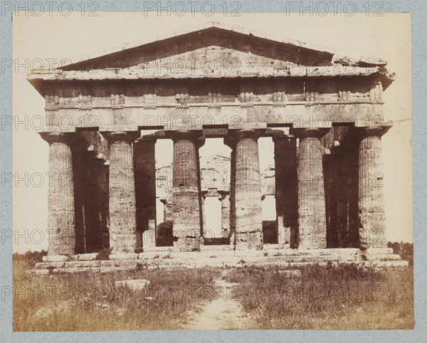 Tempio di Nettuno. Pesto, Frontal view of the Temple of Neptune in Paestum, Italy, photograph, collector's mark: 'VOSMAER', inscription, photographer: attributed to Giorgio Sommer, Paestum, 1857 - 1914, Giorgio Sommer, photographer, Attributed to, pasteboard, paper, albumen print, albumendruk, height 250 mm x width 325 mm, ruin of a building, architecture, temple, shrine, non-Christian religions, Second Temple of Hera, An aged stone structure with a triangular pediment atop a horizontal entablature sits on a raised stepped platform, supported by a row of fluted columns with simple capitals, some columns showing weathered and eroded surfaces, and gaps between them revealing more ruins behind; the foreground shows uneven grassy ground and scattered stone blocks leading to the structure, and the whole scene is framed by a pale border.