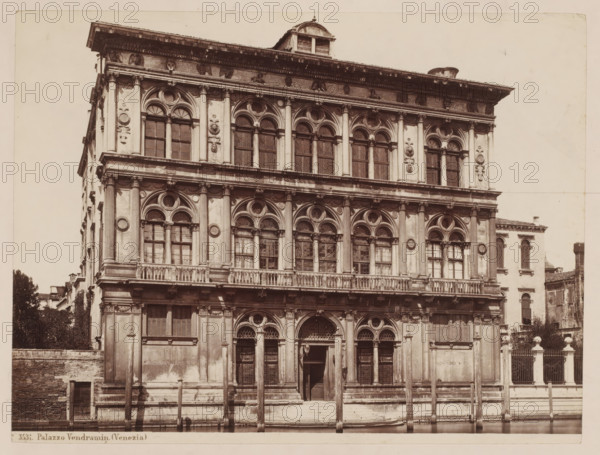 View of the Palazzo Vendramin in Venice, Italy, Palazzo Vendramin (Venezia), photograph, number: '6', inscription: 'I', collector's mark: 'RICH SCHOOL FOR ART HANDBOOK, GROUP', number: 'No. 3531.', inscription: 'Venice pal. Vendramin Calerghi', photographer: attributed to Giorgio Sommer, Venice, 1857 - 1914, Giorgio Sommer, photographer, Attributed to, pasteboard, paper, albumen print, height 320 mm x width 478 mm, hôtel, ie small palace in city, Palazzo Vendramin-Calergi, A front view of a multi-story stone building with ornate arched windows and decorative columns on each level, featuring carved circular and floral motifs between the windows and a balustraded balcony running across the middle level; the ground level shows arched doorways with wooden doors and metal grilles, flanked by pilasters and columns, and a set of steps leading up from a waterfront where wooden mooring posts rise from the water; the uppermost portion has a projecting cornice with sculpted detailing and a small ...