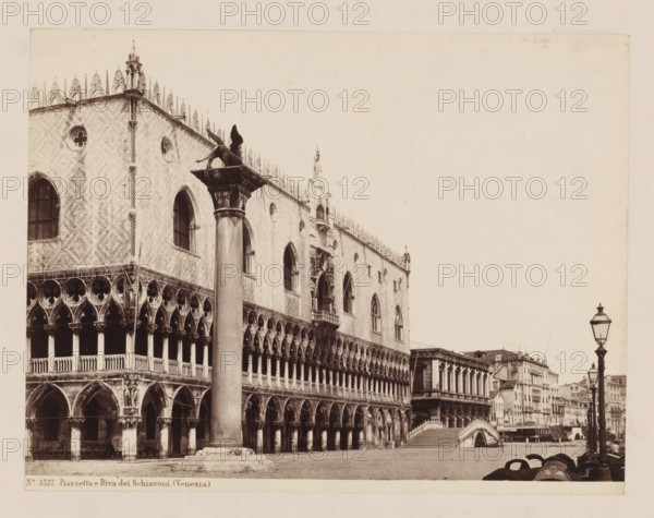 View of the Piazzetta and Riva dei Schiavoni in Venice, Italy, Piazzetta e Riva dei Schiavoni. (Venezia), photograph, inscription: 'Box 22, = Sommer (van 1182-W)', inscription: 'Venice Doge Palace', number: 'No. 3527.', inscription: 'I', collector's mark: 'RIJKS SCHOOL FOR ART NIJVERINGEN, GROEP', inscription: 'H', photographer: attributed to Giorgio Sommer, Venice, 1857 - 1914, Giorgio Sommer, photographer, Attributed to, pasteboard, paper, albumen print, albumendruk, height 319 mm x width 479 mm, square, circus, Piazzetta, Riva degli Schiavoni, A sepia-toned photograph of an ornate Gothic building with arched colonnades and patterned masonry, showing multiple rows of pointed arches, circular windows, and decorative stone tracery, a tall column topped by a winged lion sculpture standing in front of the facade, a small bridge leading to another building with classical columns, a row of street lamps and waterfront buildings receding into the distance, barrels and mooring posts along the...