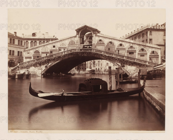 Venezia. Ponte Rialto, View of the Ponte Rialto in Venice, Italy, photograph, collector's mark: 'RICH SCHOOL FOR ARTISTS, GROUP', number: 'No. 3522.', number: '37', photographer: attributed to Giorgio Sommer, Venice, 1857 - 1914, Giorgio Sommer, photographer, Attributed to, pasteboard, paper, albumen print, albumendruk, height 319 mm x width 479 mm, landscape with bridge, viaduct or aqueduct, canals, waters (in city), gondola, Canal Grande, Ponte Rialto, A stone arch bridge with decorative balustrades spans a canal, flanked by buildings with arched windows and shutters; gondolas float in the water beneath and in the foreground, one with a covered cabin and carved prow is moored near a stone quay with wooden posts and canopied stalls visible along the right bank.