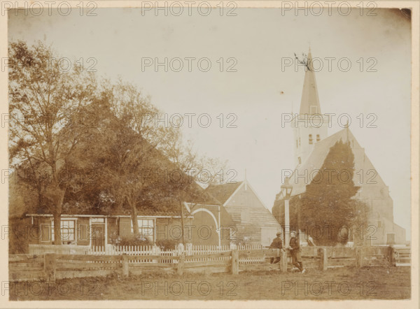 View of a farm and the Reformed Church in Den Hoorn, Texel, photograph, annotation: 'Church in Den Hoorn Texel', annotation: '16 1, 2', Den Hoorn (Texel), 1890 - 1910, photographer, paper, pasteboard, daylight collodion silver print, height 119 mm x width 163 mm, height 219 mm x width 269 mm, church (exterior), farm (building), A faded sepia photograph shows a village scene with a row of buildings partially obscured by tall leafy trees on the left and a steep church roof and tall pointed steeple on the right. In front of the buildings a picket fence runs horizontally, interrupted by a wooden gate and a larger arched doorway set into a barnlike structure. A lamp post stands near the center right beside a low wooden fence and two men wearing caps and coats lean against the fence facing each other. The ground in the foreground is grassy and the sky above is pale and empty.