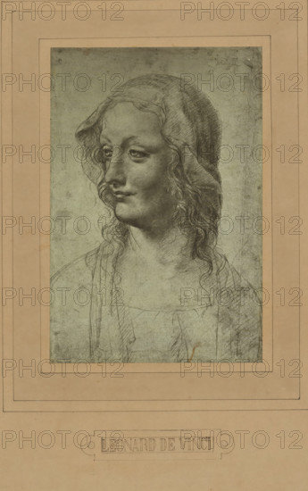 Photo reproduction of a drawing by Leonardo da Vinci (head of a woman), photograph, photographer: Adolphe Braun & Cie., 1880 - 1900, pasteboard, paper, carbon print, paper on cardboard, height 231 mm x width 155 mm, A framed pencil drawing of a person shown from the shoulders up facing slightly to the viewer's left, with long wavy hair partly covered by a thin head covering, softly modeled facial features including downcast eyes, a straight nose, and closed lips, and delicate shading and crosshatching throughout the hair, face, neck, and clothing, set against a textured muted background and mounted on a wide rectangular mat with layered borders.