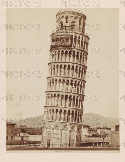 Tower of Pisa, PISA . Il Campanile, photograph, annotation, number: '3365.', Pisa, c. 1875 - c. 1900, photographer, Tuscany, paper, pasteboard, albumen print, albumendruk, height 247 mm x width 193 mm, four-wheeled, animal-drawn vehicle, eg: cab, carriage, coach, tower, clock tower, monumental adornment, A tall, leaning stone tower with multiple tiers of arched openings and decorative columns rises from a base featuring ornate geometric panels and a doorway; scaffolding and a railing are visible near the upper portion of the tower. The foreground shows a paved area with a horse-drawn carriage and a carriage driver near the tower base, along with a low fence and a lamppost. Surrounding the tower are low buildings and walls, and distant hills form the backdrop beneath a pale, empty sky.