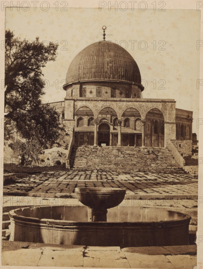 Mosque of Omar., View of the Dome of the Rock Mosque in Jerusalem, photograph, inscription: 'Omar Mosque Jerusalem', Jerusalem, c. 1875 - c. 1900, photographer, paper, pasteboard, albumen print, albumendruk, height 250 mm x width 188 mm, utilitarian, public pump or water fountain, dome, architecture, temple, shrine, non-Christian religions, Dome of the Rock, A sepia-toned photograph showing a large domed building with a rounded roof topped by a decorative finial, a colonnaded façade with arches, and a broad flight of worn stone steps leading up to the entrance; in front of the steps a paved courtyard with irregular stone slabs is visible, and a circular stone fountain basin with a raised central bowl sits in the foreground; a large tree with dense foliage occupies the left side of the image, and the building’s exterior shows patterned panels and window openings beneath the dome.
