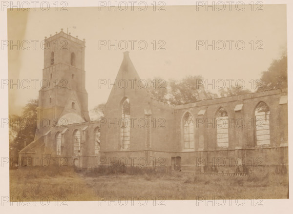 View of the Reformed Church in Middelharnis after the fire, photograph, annotation: 'Church of the NH community, 5 July 1904, Middelharnis', annotation: 'Middelharnis (ZH), Church of the Ned. Herv municipality, 5 July 1904', Middelharnis, 1904, photographer, Attributed to, paper, pasteboard, albumen print, albumendruk, height 160 mm x width 231 mm, church (exterior), A sepia-toned photograph shows a large brick building with tall arched window openings, many of which are empty or boarded, and a tall square tower with small windows and a balustraded top. The roofline is partially missing, exposing the triangular gable end with a pointed top and an arched opening, and sections of masonry show discoloration and weathering. Trees and foliage are visible behind and alongside the structure, and an expanse of grassy ground stretches across the foreground. The image has a faded, aged appearance with soft contrasts and uneven shading.