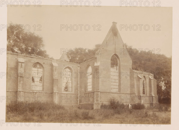 View of the Reformed Church in Middelharnis after the fire, photograph, annotation: 'Middelharnis (ZH), Kerk der Ned. Rev. congregation, on July 5, 1904', annotation: 'Kerk der Ned. Rev. Municipality, on 5 July 1904, Middelharnis', Middelharnis, 1904, photographer, Attributed to, paper, pasteboard, albumen print, albumendruk, height 164 mm x width 230 mm, church (exterior), A sepia-toned photograph showing the exterior of a large brick building with tall arched window openings, many of which are missing glass and have visible wooden supports; the building has buttresses and a steep gable end with a narrow top, and a vertical drainpipe runs down one corner; trees and foliage appear behind and to the sides of the structure, and unkempt grass fills the foreground.