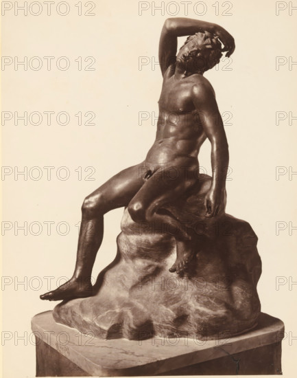 Bronze sculpture of a sleeping satyr, Museo di Napoli Fauno, album page, photograph, This photo is part of an album., number: '1505', workshop stamp: 'Giorgio Sommer, Largo Vittoria, Napoli', photographer: Giorgio Sommer, Naples, 1874 - in or before 1879, paper, albumen print, height 252 mm x width 195 mm, satyr(s) (in general), sculpture (bronze, arts), A dark-toned sculpture of a seated nude male figure resting on an irregular rocky base is shown against a pale background, the figure leaning back with one arm bent over his head and the other arm hanging down beside him, detailed muscular anatomy visible across the torso and limbs, one leg extended forward with the foot resting on the rock while the other leg is bent, the head tilted and eyes closed, textured rock surface beneath the figure and a rectangular plinth supporting the composition.
