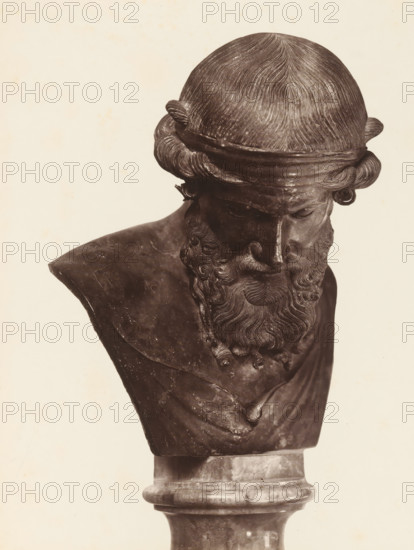 ... Museo di Napoli, Sculpture of Dionysus, album page, photograph, This photo is part of an album., number: '1836', workshop stamp: 'Giorgio Sommer, Largo Vittoria, Napoli', photographer: Giorgio Sommer, Naples, 1874 - in or before 1879, paper, albumen print, height 253 mm x width 187 mm, sculpture, (story of) Bacchus (Dionysus), Liber, A close-up photograph of a dark sculpted bust showing the head and upper torso on a rounded pedestal, with finely textured hair styled in smooth, combed waves and looped side curls, a band across the forehead, a full curly beard with detailed carved waves, a downcast facial expression with closed or lowered eyes and a prominent nose, and draped clothing over the shoulders with visible sculpted folds; the sculpture appears dark against a light, plain background.