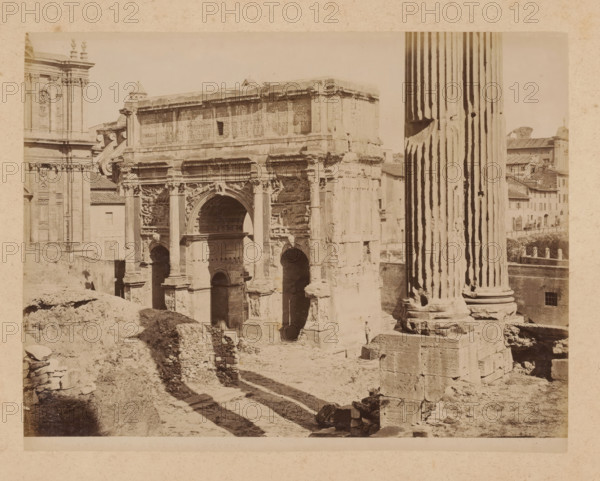 View of the Arch of Septimius Severus on the Roman Forum in Rome, album page, photograph, This photo is part of an album., inscription: '18 ARCO DI SEPTIMIO-SEVERO', Rome, 1870 - c. 1895, photographer, paper, pasteboard, albumen print, height 199 mm x width 258 mm, triumphal arch, Arch of Septimius Severus, A sepia-toned photograph of a large ancient stone arch and surrounding ruins with carved reliefs and architectural details, flanked on the right by a tall fluted column standing on a multi-tiered base and on the left by part of a classical building façade with decorative pilasters and sculptural elements; the arch shows multiple openings and ornate carvings above and around the central arched passage, with worn stone surfaces and broken fragments visible; in the foreground uneven ground, rubble, and collapsed masonry create rough paths and shadows leading toward the structure, and a distant cluster of tiled-roof buildings is visible beyond the column.